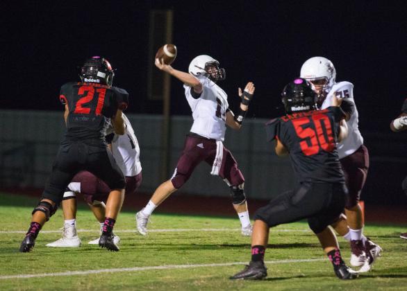 Examiner photo by Patricia Renick Iola Bulldog quarterback Blake Driver throws for a long pass with good blocking from #75 Clayton Costello and #17 Colton Bouillon. Article Image Alt Text