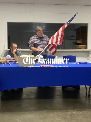 Examiner photo by Matthew Ybarra During the June 8, meeting, Anderson Mayor Marc Benton shows councilmembers new flags and flag mounts that will line historic Main Street. Article Image Alt Text