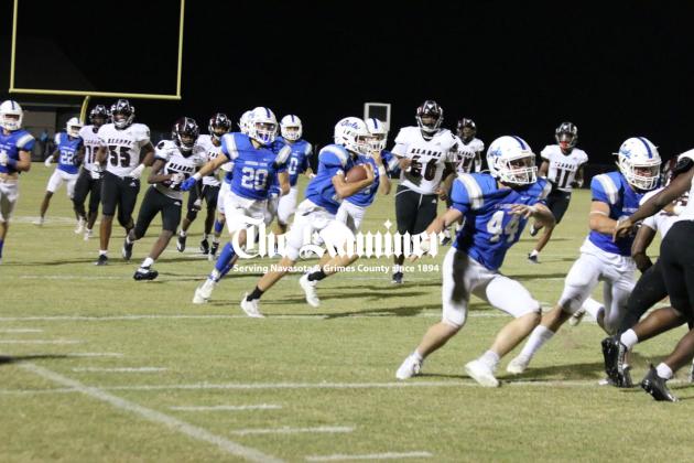 Kagan Stephens (12) follows blocks from a parliament of Owls including Mason Kolby (44) and William Lee (32) for a spectacular punt return in the fourth quarter against the Hearne Eagles. Trailing the play is senior Pedro Martinez (20). Anderson-Shiro plucked their way to a 28-6 season-opening win. Photo by Carter Benton Article Image Alt Text